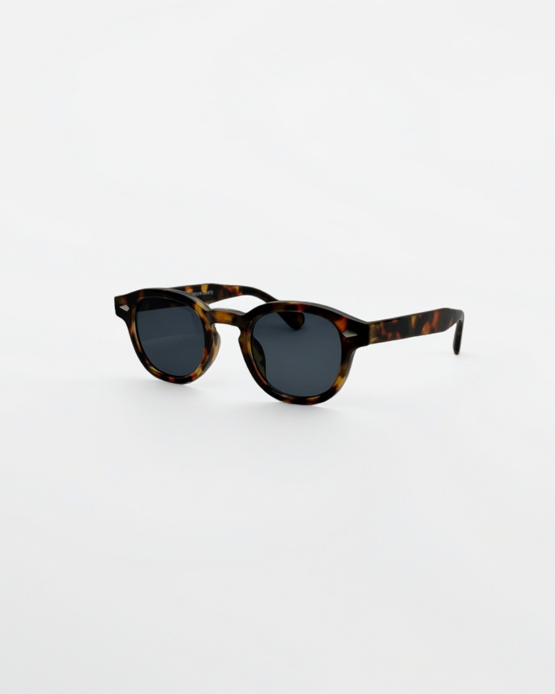 Close-up product view of harbor tortoise black sunglasses by Alga, showing the frame and lenses.