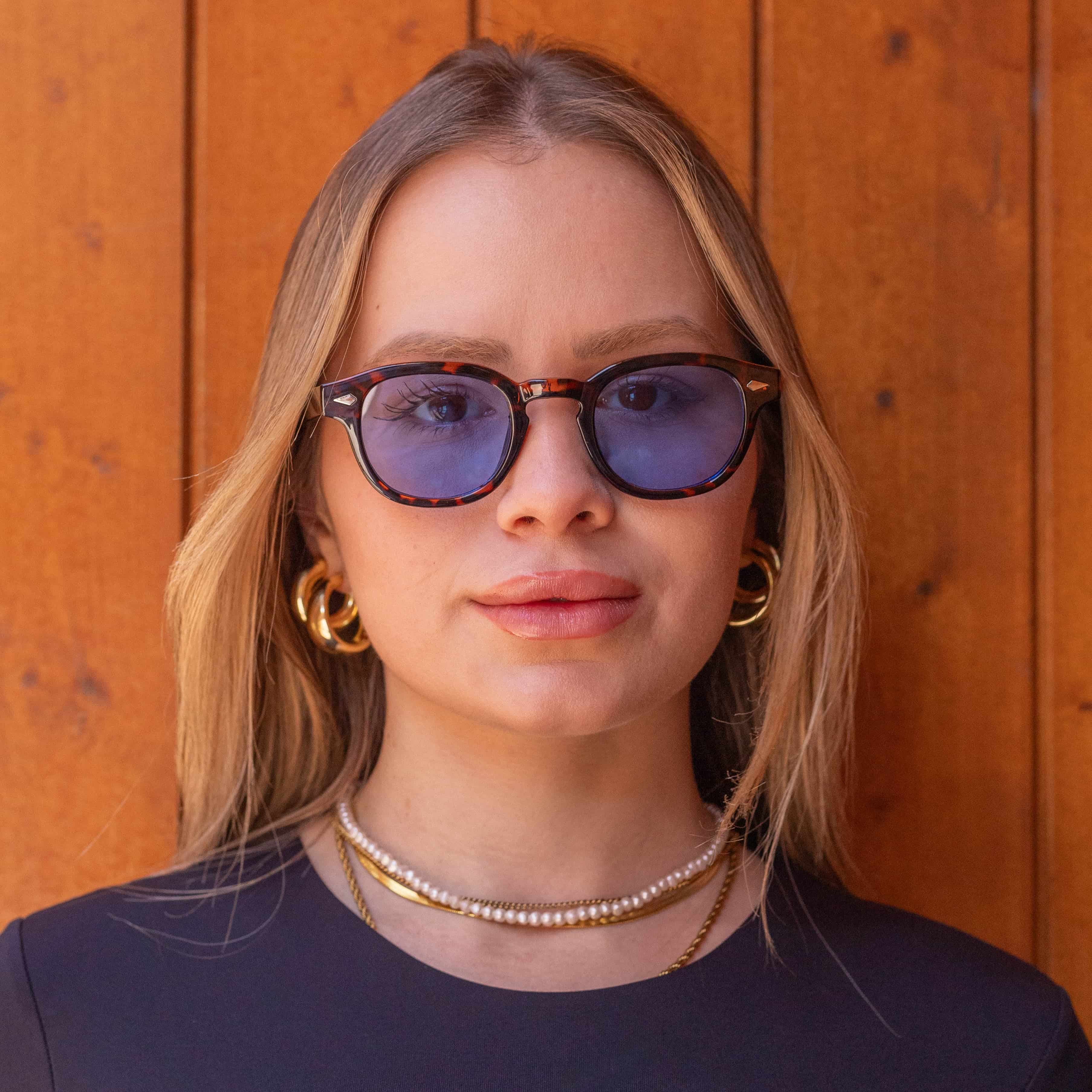 Model wearing Deep Tortoise sunglasses with gradient blue lenses, showcasing a bold and stylish look.