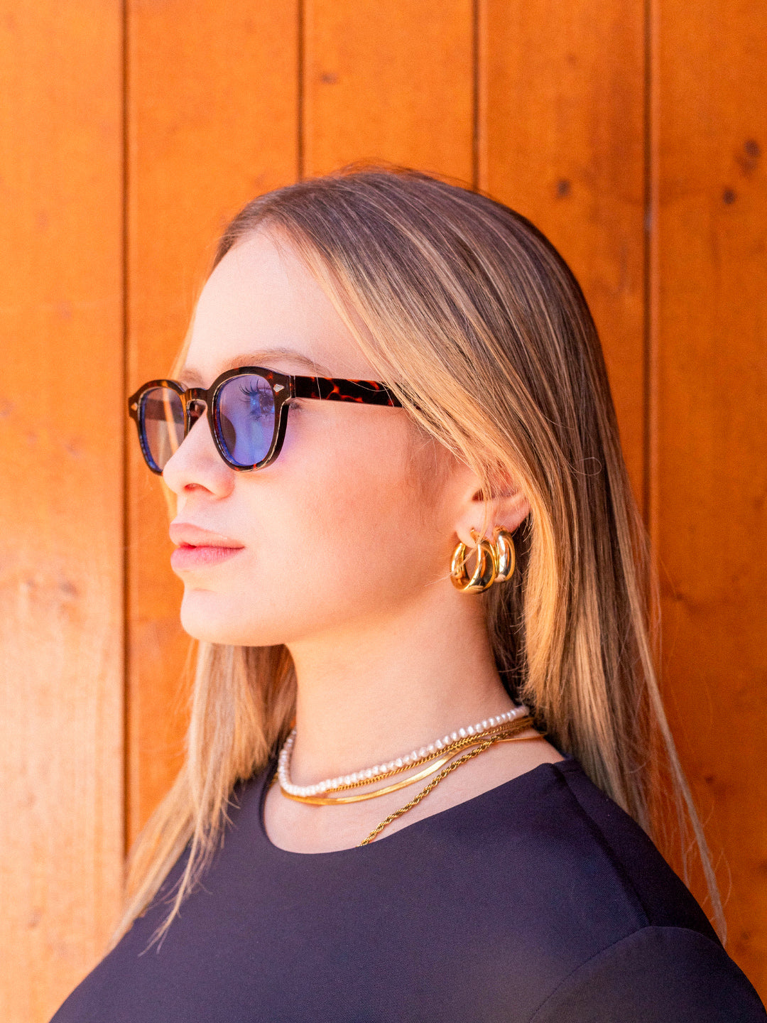 Portrait of a person wearing harbor tortoise blue sunglasses by Alga.